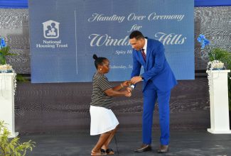 Prime Minister, the Most Hon. Andrew Holness (right), hands Shauna Adderly the keys to her new home in the Windsor Hills housing development in Trelawny on Wednesday (September 27). A total of 77 solutions were handed over under phase one of the National Housing Trust (NHT) project.