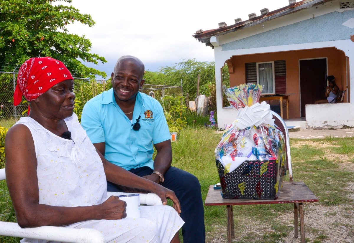 Minister of Labour and Social Security, Hon. Pearnel Charles Jr., shares pleasantries with centenarian and resident of Comfort District, Toll Gate, Clarendon, Enid Daley, after presenting her with a gift basket on Friday (October 6). Ms. Daley was among several residents in the parish receiving gift baskets from Minister Charles in commemoration of Senior Citizens Month.

