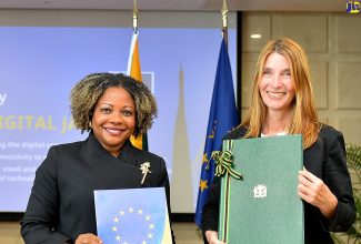 Minister without Portfolio in the Office of the Prime Minister with oversight for Skills and Digital Transformation, Senator Dr. the Hon. Dana Morris Dixon (left), and Deputy Secretary General for Economic and Global Affairs at the European Union, Helena Konig (right), display documents during the Digital Jamaica Exchange of Documents Ceremony held at the Ministry of Foreign Affairs and Foreign Trade in downtown Kingston on Tuesday (October 10).
