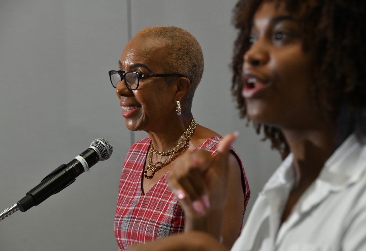 Minister of Education and Youth, Hon. Fayval Williams (left), delivers remarks during Thursday’s (October 12) National Youth Mental Health Summit held at the AC Hotel by Marriott in Kingston. At right is sign language interpreter, Mandy Cowan.