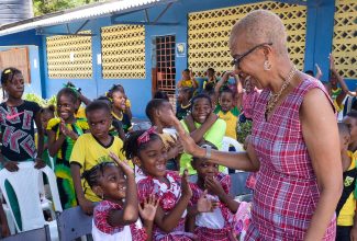 Minister of Education and Youth, Hon. Fayval Williams, gives high-fives to students at St. Andrew Primary School, during a visit to share in the Heritage Day celebrations at the institution in Kingston on October 12.