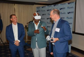 Tourism Minister, Hon. Edmund Bartlett (centre), is joined by Executive Chairman, Sandals Resorts International, Adam Stewart (left), and President, EON Reality, Mats Johansson, as he interacts with Spatial AI technology at Sandals Royal Plantation in Ocho Rios, St. Ann, on Thursday (October 5). The occasion was the launch of the EON Reality and Sandals Corporate University (SCU) training and development partnership.

