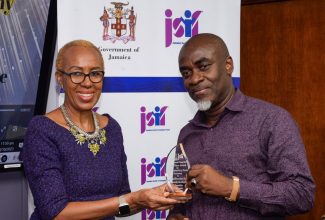  Minister of Education and Youth, Hon. Fayval Williams (left), presents the award for ‘Most Outstanding Closing Ceremony’ to President of the Norwood Benevolent Society Community Development Committee, Dalton Spence. Occasion was the Summer Camp Awards under the Jamaica Social Investment Fund’s  (JSIF) Integrated Community Development Programme (ICDP) Phase 2, held at JSIF’s offices in Kingston on October 4.