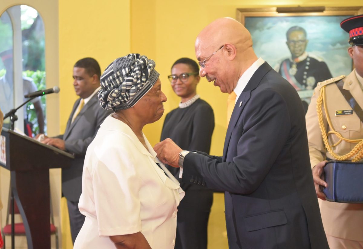 Governor-General, His Excellency the Most Hon. Sir Patrick Allen (right), pins the Medal of Honour on the lapel of former King’s House staff member, Joy Scott, at the awards ceremony held on Thursday (September 28) at King’s House.