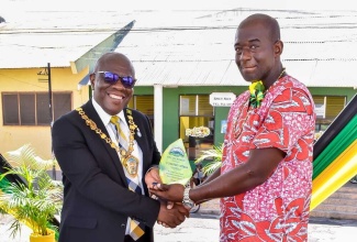 Chairman of the Trelawny Municipal Corporation and Mayor of Falmouth, Councillor Collen Gager (left), presents the inaugural Civic Pride Award to Courtney “Dappa” Yetman for contribution to the preservation of civic pride in this parish. The presentation was made at the National Heroes Day Civic and Awards ceremony held in Water Square on October 16.

