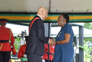 Governor-General, His Excellency, the Most Hon. Sir Patrick Allen, congratulates renowned filmmaker, Natalie Thompson, as she is conferred with the Order of Distinction in the rank of Officer (OD), during the National Honours and Awards Ceremony at King’s House on October 16.