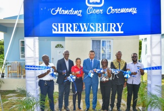Prime Minister, the Most Hon Andrew Holness (centre), officially opens phase two of the Shrewsbury development in Petersfield Westmoreland on Wednesday (October 25). The development was undertaken by the National Housing Trust (NHT). Also participating in the ribbon-cutting exercise are (from left) NHT Board Director, Doran Dixon, and Managing Director, Martin Miller; beneficiaries, Amoy Evans and Karlene Mitchell; Member of Parliament, Westmoreland Central, George Wright; and beneficiary, Jean-Pierre McKenzie.

