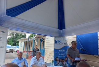 Chairman of the Western Regional Health Authority (WRHA) Eric Clarke, addresses residents, healthcare workers and other stakeholders at the recent ceremony for the adoption of the Ulster Spring Health Centre in Trelawny. Seated (left to right) are Custos of Trelawny, Hugh Gentles; and President of the Jamaica Organization of New Jersy and Donor, Owen Eccles. The facility is one of 46 that have been adopted through the Ministry of Health and Wellness’ Adopt-a-Clinic initiative throughout the island.

