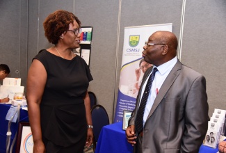Chief Executive Officer, Kingston Public Hospital, Dr. Natalie Whylie (left) in discussion with Consultant and General, Vascular and Laparoscopic Surgeon, Dr. Neville Graham during the Kingston Public Hospital’s (KPH) 16th Annual Clinical and Scientific Conference, held recently at the Jamaica Pegasus Hotel in Kingston. The conference was held under the theme ‘KPH: A Beacon for Medical Development and Excellence’.
 