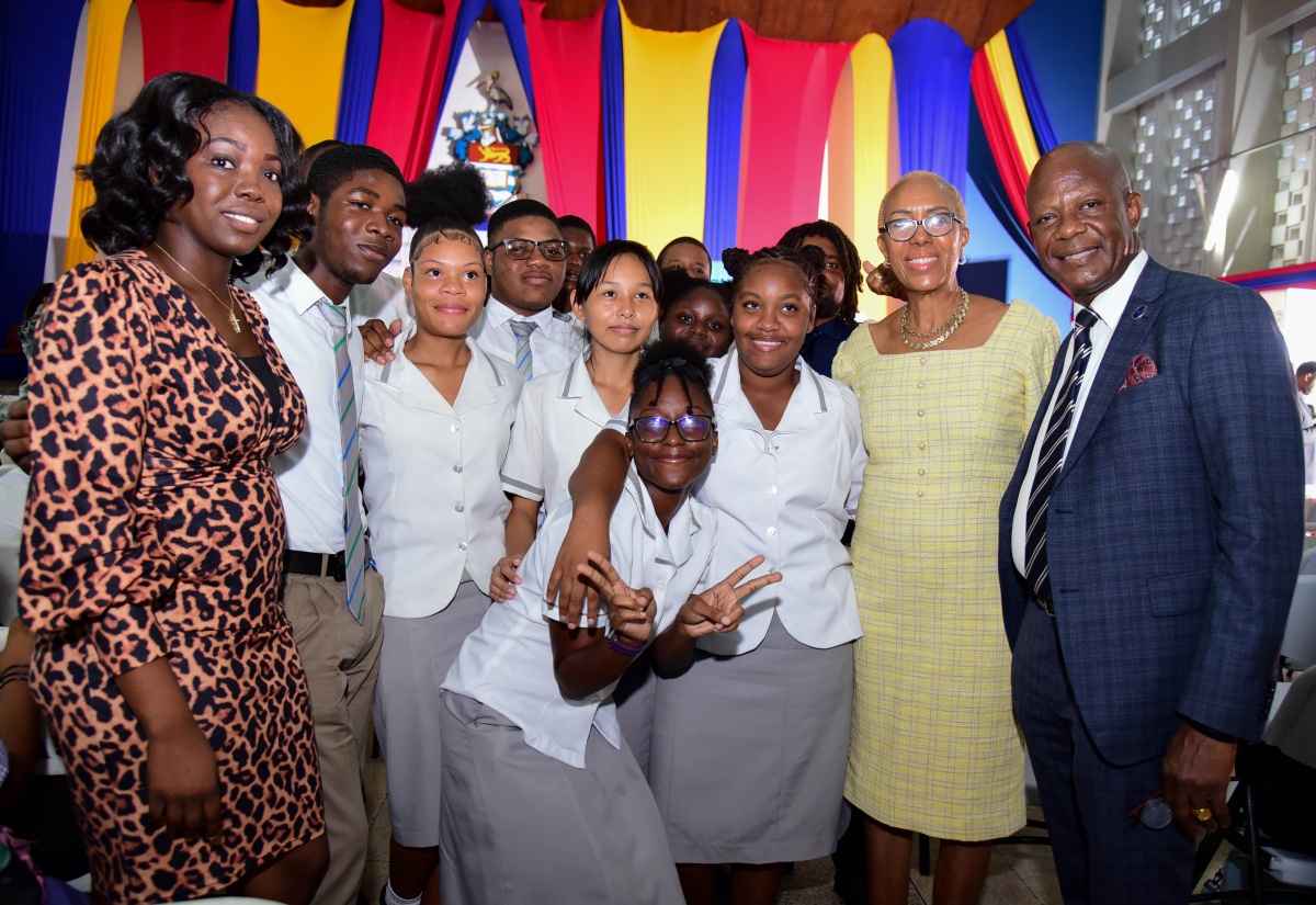 Minister of Education and Youth, Hon. Fayval Williams (second right), and Chief Executive Officer, Universal Service Fund (USF), Dr. Daniel Dawes (right), share a photo opportunity with Vauxhall High School USF ICT Club members during Friday’s (November 10) club launch and pinning ceremony at the University of the West Indies (UWI), Mona, Assembly Hall. At left is educator at Vauxhall High School, Kevene Harris.