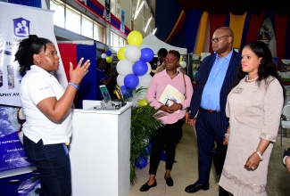 Geographic Information Systems (GIS) Analyst, National Housing Trust (NHT), Shauntelle Ricketts (left), engages with from (from second left) Head of Department/Senior Lecturer and Museum Curator, Department of Geography and Geology, University of the West Indies (UWI) Mona,  Dr. Sherene James-Williamson;  Vice President and Executive Director of Trimble, Albert Momo; and Director General in the Ministry of Economic Growth and Job Creation, Dr. Sharon Morrison. The occasion was the 21st National Geographic Information Systems (GIS) Day event held on November 15 at the Mona campus in St. Andrew.

