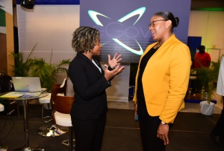 Minister without Portfolio in the Office of the Prime Minister with Responsibility for Skills and Digital Transformation, Senator Dr. the Hon. Dana Morris Dixon (left), speaks with Acting Chief Executive Officer of eGov Jamaica Limited, Anika Shuttleworth, during today’s (November 29) second annual Government of Jamaica (GOJ) Technology Showcase at the AC Hotel in New Kingston.