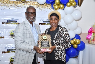 Minister of Local Government and Community Development, Hon Desmond McKenzie, presents a plaque to retiree Elaine Coombs, during the St. Ann Municipal Corporation’s Staff Awards and Retirement Banquet held at Hibiscus Lodge Hotel in Ocho Rios on Saturday, November 11.

