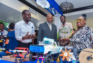 Minister of Culture, Gender, Entertainment and Sport, Hon. Olivia Grange (right), displays a clock from the Youth STEM Projects Showcase during the British Council’s Future of Creativity Symposium, held at The Jamaica Pegasus hotel in New Kingston on Monday (November 27). Others (from left) are educator, Kevin Coke; Director General, Planning Institute of Jamaica (PIOJ), Dr. Wayne Henry; and Herbert Morrison Technical High School student, Javey Heaven.

