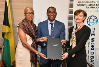 Minister of Finance and the Public Service, Dr. the Hon. Nigel Clarke; Minister of Education and Youth Hon. Fayval Williams (left), and Country Director, Caribbean Countries, World Bank, Lilia Burunciuc, display the Jamaica Education Project (JEP) Loan Agreement during a visibility ceremony held at the Ministry’s Heroes Circle offices in downtown Kingston, on November 20.