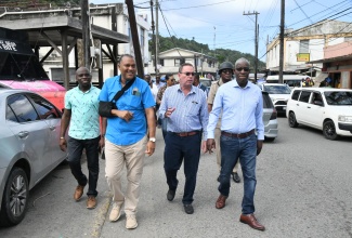 Minister of Science, Energy, Telecommunications and Transport, Hon. Daryl Vaz (second right), observes transport operations in Port Maria, St. Mary, during a recent visit to the town. Among those accompanying the Minister are Mayor of Port Maria, Richard Creary (second left); and Chairman of the Transport Authority, Owen Ellington (right).