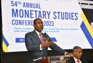 Minister of Finance and the Public Service, Dr. the Hon. Nigel Clarke, emphasises a point at the 54th annual monetary studies conference at the Bank of Jamaica, downtown Kingston, on November 1. At right is Governor, Bank of Jamaica, Richard Byles.