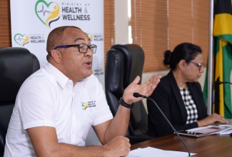 Minister of Health and Wellness, Dr. the Hon. Christopher Tufton, addresses a press conference at his New Kingston offices, today (November 9). Pictured at right is Chief Medical Officer (CMO), Dr. Jacquiline Bisasor-McKenzie.