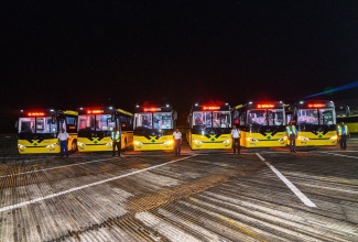 JUTC employees pose for a photo in front of the buses