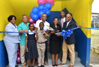  State Minister in the Ministry of Education and Youth, Hon. Marsha Smith (second right) is assisted by Managing Director of the Jamaica Social Investment Fund (JSIF), Omar Sweeny (right) to cut the ribbon to officially open the new classroom block at Grange Hill Primary School in Westmoreland on Thursday (November 2). Sharing in the moment are (from left) Regional Director in the Ministry of Education and Youth, Region 4, Dr. Michelle Pinnock; Grange Hill Primary board chairman, Samuel Williams; Head Girl at the institution, Kenneise Sortie; Head Boy, Theomar McKenzie; Member of Parliament for Westmoreland Western, Morland Wilson and Principal, Clayton Smith.