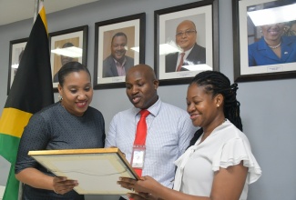 CEO/Commissioner at the Jamaica Customs Agency (JCA), Velma Ricketts Walker (left); Sean Barrow, ISO Project Director (centre); and Celia Russell-Henry, ISO Project Manager, examine the ISO 9001:2015 Certificate awarded to Jamaica Customs – the country