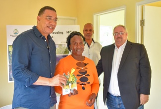 Prime Minister, the Most Hon. Andrew Holness (left), and new homeowner, Marvaree Anderson (centre), display the keys to a three-bedroom house, built under the New Social Housing Programme (NSHP), during a recent handover of the unit in Elgin, Clarendon. Also sharing the moment are Member of Parliament for Clarendon North Western, Phillip Henriques, and Councillor for the Frankfield Division, Clive Mundle.