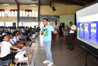 Legal Education Officer, Ministry of Legal and Constitutional Affairs, Ivan Godfrey (right) speaks to a group of Cedar Grove Academy students about the voting process during the Ministry’s Road to Republic School Tour, which was launched on November 23, at the St. Catherine based institution. The tour aims to sensitize fifth and sixth form students who are at the age of majority or are likely to attain the age of majority, within this current parliamentary term on Jamaica’s transition from a Constitutional Monarchy to a Republic.