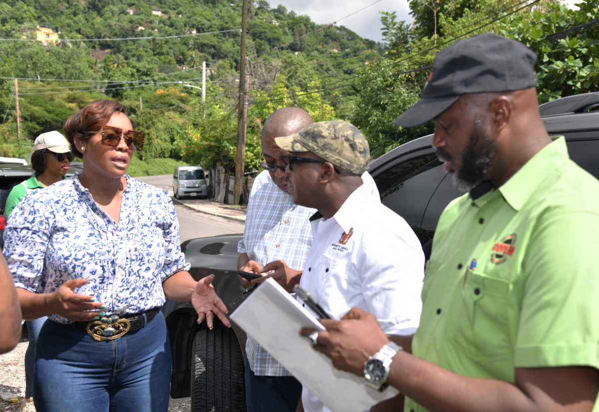 Member of Parliament, East Rural St. Andrew, the Most Hon. Juliet Holness (left), makes a point to Minister of Labour and Social Security, Hon. Pearnel Charles Jr (second right), during a tour of the constituency on Saturday (Nov. 18), to assess the impact of the recent heavy rains. Listening are Acting Director General, Office of Disaster Preparedness and Emergency Management, Richard Thompson (right); and Councillor for the Tivoli Gardens Division, Donovan Samuels.