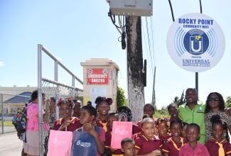 Minister of Labour and Social Security, and Member of Parliament for Clarendon South Eastern, Hon. Pearnel Charles Jr. (second right, back row), shares a photo opportunity with students of the Salt Savannah Primary School during the recent launch of the Universal Service Fund (USF) Community Wi-Fi in Rocky Point in the parish. Minister Charles Jr. is joined by Guidance Counsellor at the school, Sebenia Aikens (right).

