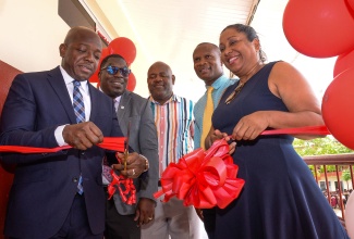 Minister of Labour and Social Security, and Member of Parliament for Clarendon South Eastern, Hon. Pearnel Charles Jr., cuts the ribbon to open a new Smart Room at the Mineral Heights Primary School. The facility was handed over by the Foundation on November 14. Sharing the moment (from left) are Minister of Education and Youth Regional Director, Region 7, Barrington Richardson; Mineral Heights Primary School Board Chairman, Collin Coke; Principal, Lanzeford Howell; and CEO of the Digicel Foundation, Charmaine Daniels.