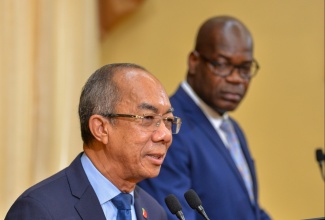 Deputy Prime Minister and Minister of National Security, Hon. Dr. Horace Chang (left), addressing Wednesday’s (November 15) post-Cabinet press briefing at Jamaica House. Listening is Deputy Commissioner of Police Fitz Bailey.