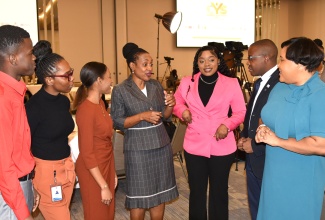 Minister of State in the Ministry of Education and Youth, Hon. Marsha Smith (centre), in discussion with participants at the opening of the inaugural four-day Caribbean Youth Summit (CYS), being held at the AC Mariott Hotel in New Kingston on November 22.

 