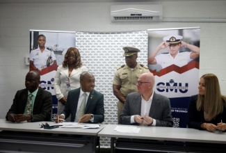 Caribbean Maritime University (CMU) President, Professor Andrew Spencer (third left), speaks with Carnival Corporation’s Vice President of Crew and Travel Operations, Richard Brearley (second right); and Manager, Marine Talent Attraction, Carnival Cruise Line, Mihaela Costache (right), during the signing of a Memorandum of Understanding (MOU), which will provide maritime training for CMU students over the next five years. Others (from left) are CMU’s Vice President of Academic Affairs and Accreditation, Professor Noel Brown; Vice President of Administration/University Registrar, CMU, Keisha Walker; and Captain Devron Newman from the CMU’s Faculty of Marine & Nautical Studies.

 