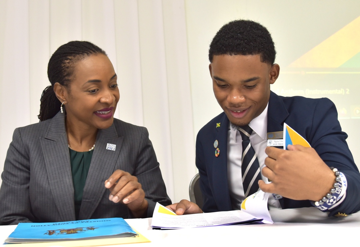 Minister of State in the Ministry of Education and Youth, Hon. Marsha Smith (left), peruses a document with President of the National Secondary Students Council, Cavan Lewis at the National Student Leaders Installation Ceremony held at the Medallion Hall Hotel in Kingston on November 16.