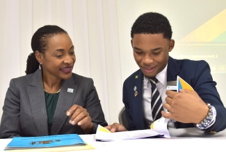 Minister of State in the Ministry of Education and Youth, Hon. Marsha Smith (left), peruses a document with President of the National Secondary Students Council, Cavan Lewis at the National Student Leaders Installation Ceremony held at the Medallion Hall Hotel in Kingston on November 16.