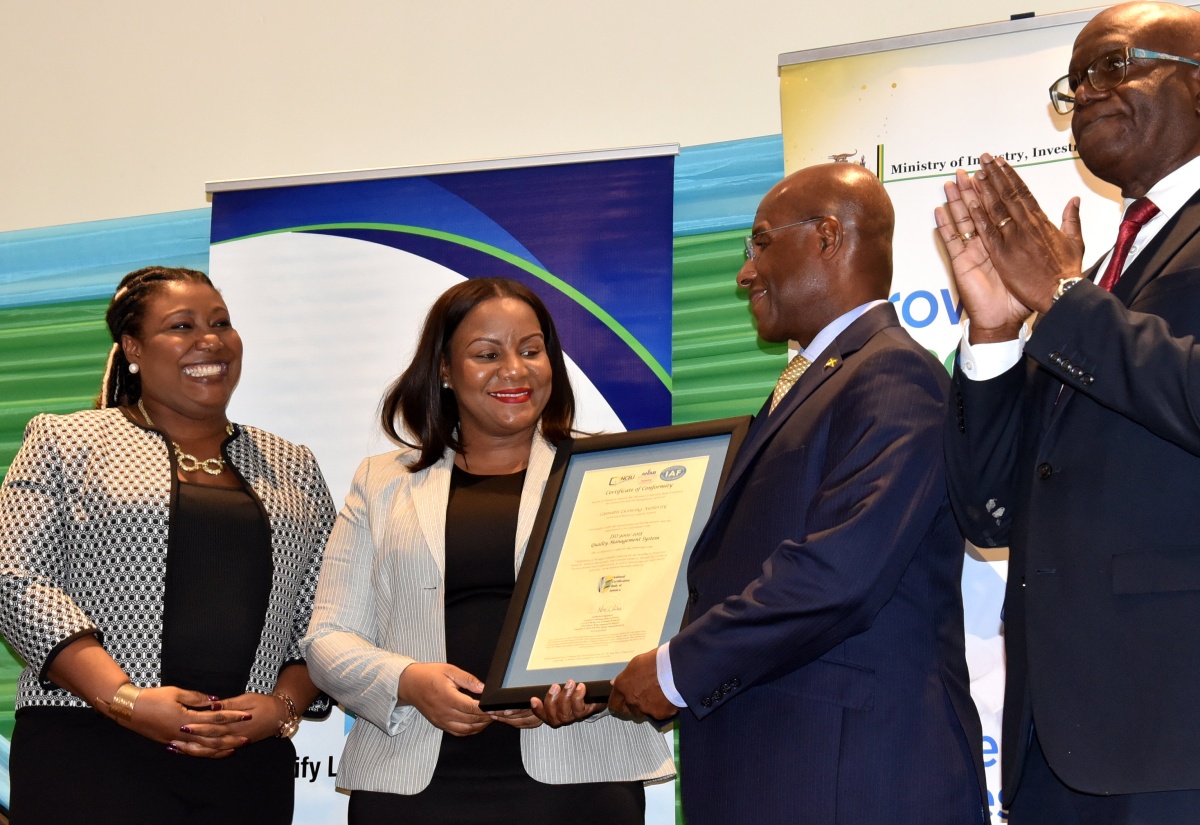Minister of Industry, Investment and Commerce, Senator the Hon. Aubyn Hill (second right) presents a certificate to Chief Executive Officer of the Cannabis Licensing Authority, Farrah Blake, during the National Certification Body of Jamaica (NCBJ)World Quality Week Certificate Handover Ceremony at The Jamaica Pegasus hotel in New Kingston on November 9. Sharing the moment (from left) are Manager, NCBJ, Navenia Wellington Ford and Executive Director of the Bureau of Standards Jamaica, Dr. Velton Gooden.