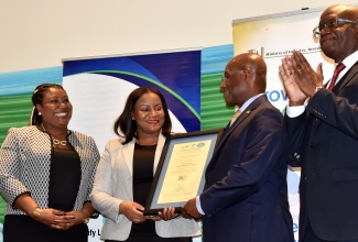 Minister of Industry, Investment and Commerce, Senator the Hon. Aubyn Hill (second right) presents a certificate to Chief Executive Officer of the Cannabis Licensing Authority, Farrah Blake, during the National Certification Body of Jamaica (NCBJ)World Quality Week Certificate Handover Ceremony at The Jamaica Pegasus hotel in New Kingston on November 9. Sharing the moment (from left) are Manager, NCBJ, Navenia Wellington Ford and Executive Director of the Bureau of Standards Jamaica, Dr. Velton Gooden.