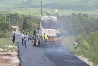 Workmen repair a section of roadway as part of the ongoing Essex Valley Agricultural Development Project (EVADP), in St. Elizabeth.