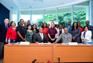 Dean of the Consular Corps of Jamaica, Robert Scott (left, seated) and Vice Chancellor, University of the West Indies (UWI), Sir Hilary Beckles (right, seated), with Corps members and other stakeholders following the signing of a Memorandum of Understanding (MOU) between the institutions during a ceremony held at the UWI Regional Headquarters in Kingston on Thursday (December 14). Others present include Minister of State in the Ministry of National Security, Hon. Juliet Cuthbert Flynn (left); Minister of Foreign Affairs and Foreign Trade, Senator the Hon. Kamina Johnson Smith (centre) and Minister of State in the Ministry of Education and Youth, Hon. Marsha Smith (second right).

