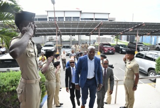 Minister of Labour and Social Security, Hon. Pearnel Charles Jr. (centre), is saluted by cadets as he enters the Caribbean Maritime University (CMU) at Palisadoes Park, Kingston, for a recent tour. Accompanying him are Minister of State in the Labour Ministry, Dr. the Hon. Norman Dunn (second right), and CMU President, Professor Andrew Spencer (fourth left). The visit was geared towards developing future collaboration and strengthening ongoing relations.