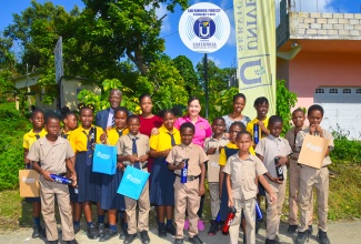 Chief Executive Officer of the Universal Service Fund (USF), Dr. Daniel Dawes (fifth left); and Member of Parliament for Portland Eastern, Ann-Marie Vaz (centre), are surrounded by students and teachers from the Sherwood Forest Primary School, during the launch of Wi-Fi service in the Portland-based community on November 30.

 
