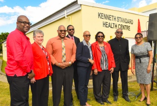 Minister of Education and Youth and Member of Parliament for St. Andrew Eastern, Hon. Fayval Williams (fourth right), attends Thursday’s (December 14) renaming ceremony for August Town/Hermitage Health Centre in the constituency. The facility’s name has been officially changed to the Kenneth Standard Health Centre, in honour of the late Jamaican medical doctor who was a cornerstone of public health development locally and regionally and made tremendous contributions to community medicine throughout the Caribbean. Also attending are (from left) Pro-Vice Chancellor and Principal of the University of the West Indies Mona Campus, Professor Densil Williams; Executive Director, Mona Ageing and Wellness Centre, Professor Denise Eldemire-Shearer; family members of the honouree – Dr. Marlon Lloyd Goldson, Christopher Lloyd Goldson, and Dr. Aileen Standard-Goldson; and Chief Medical Officer in the Ministry of Health and Wellness, Dr. Jacquiline Bisasor McKenzie.

