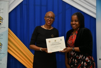 Minister of Education and Youth, Hon. Fayval Williams (left), presents data protection officer, Jacqueline Parkson, with her certificate during Friday’s (December 1) Training in Data Protection for Educators award ceremony at the University of Technology (UTech) Jamaica campus in Kingston.