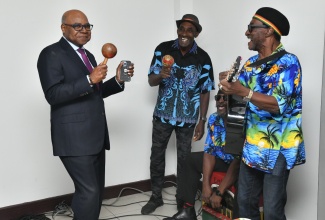 Minister of Tourism, Hon. Edmund Bartlett (left), interacts with musicians during an appreciation activity for the Norman Manley International Airport (NMIA) team on December 19. The event was held inside the Arrivals Hall at the airport.