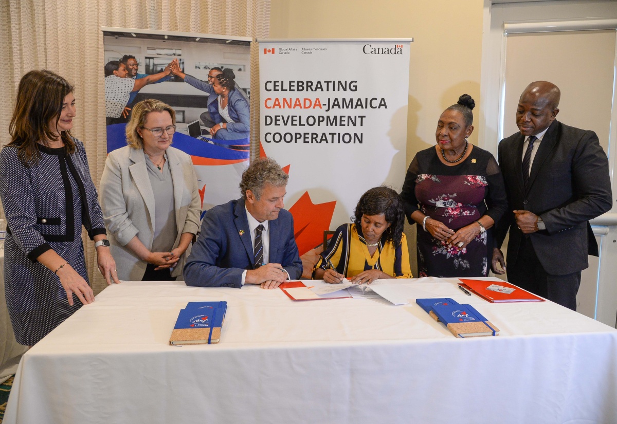 Counsellor and Head of Cooperation, Canadian High Commission in Jamaica, Dr. Christian DaSilva (left, seated), and General Manager of the Clarendon Parish Development Committee Benevolent Society, Eurica Douglas (right, seated), sign the Local Engagement and Action Fund (LEAF) grant agreement, during a ceremony at the Courtyard by Marriott in New Kingston on Thursday (December 7). Observing the signing (from right) are Minister of Labour and Social Security, Hon. Pearnel Charles Jr.; Minister of Culture, Gender, Entertainment and Sport, Hon. Olivia Grange; High Commissioner of Canada to Jamaica, Her Excellency Emina Tudakovic; and Global Affairs Canada Director General for Central America and the Caribbean, Sylvie Bedard.

