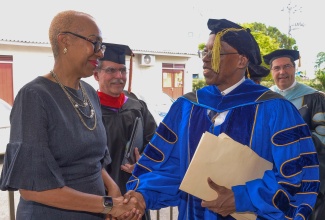 Minister of Education and Youth, Hon. Fayval Williams, is greeted by newly appointed President of the Caribbean Graduate School of Theology, Dr. Anthony Oliver, prior to his taking the oath of office during the institution’s Presidential Installation and Graduation Ceremony, on Saturday (December 2). Minister Williams delivered greetings during the ceremony, which was held at the Church of the Open Bible on Washington Boulevard in Kingston.