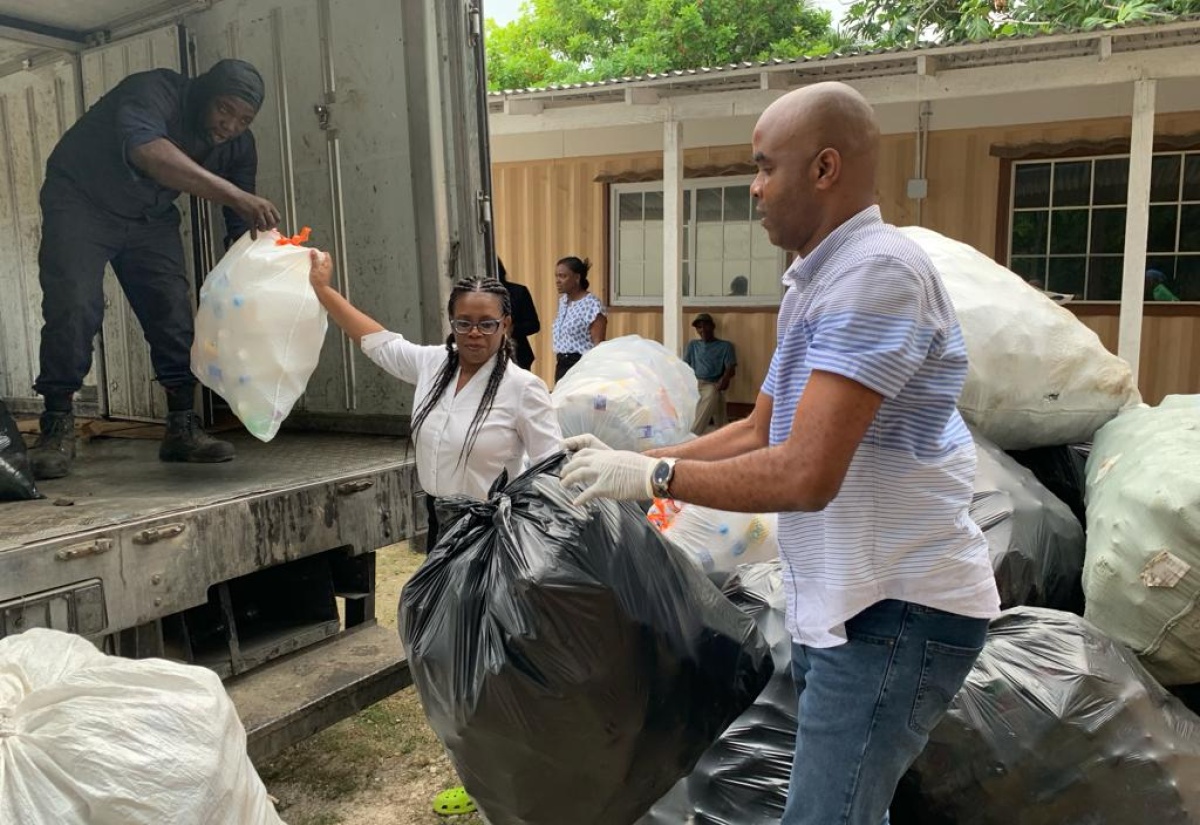 Photo # 03: Member of Parliament for Hanover West, Tamika Davis (centre), joins WPM Waste Management Limited’s crew in collecting bulk and plastic waste in a Hanover community recently. The WPM team was led by regional operations manager, Edward Muir (right).

