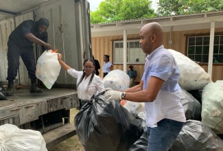 Photo # 03: Member of Parliament for Hanover West, Tamika Davis (centre), joins WPM Waste Management Limited’s crew in collecting bulk and plastic waste in a Hanover community recently. The WPM team was led by regional operations manager, Edward Muir (right).

