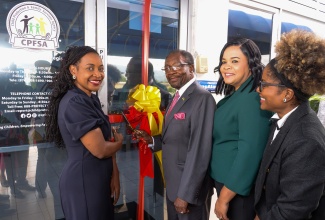 Minister of State in the Ministry of Education and Youth, Hon Marsha Smith (left), and United States Ambassador to Jamaica, His Excellency, N. Nick Perry (third right),  cut the ribbon to officially open the Child Friendly Space, at the National Children’s Registry NCR), in St. Andrew on December 15. Others participating include (from right) Country Programme Director for the Warmath Group, Aylair Livingstone and Chief Executive Officer, Child Protection and Family Services Agency (CPFSA), Laurette Adams Thomas.