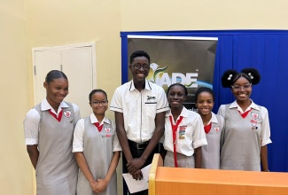 Deputy Programmes Manager for Jamaican Association for Debating and Empowerment (JADE) Limited, Xavier McFarlane, with members of the debating team of The Queen’s School in Kingston, after adjudicating in the ‘A Fi Wi Republic’ Secondary School Debating Competition. 